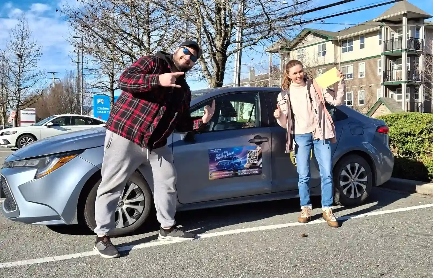 Right of Way student celebrating road-test results beside the training car